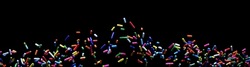 close-up sprinkle small colorful sugar candies flying. sweet food for toppings, donuts, and cakes at birthday celebrations. isolated on a black background