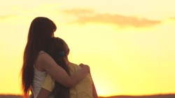 mother hugs and regrets her daughter against the backdrop of the sunset sky, love children, difficult age of teenager, take care of child's mental health, be attentive and kind, care and compassion