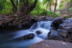 Pure water stream with smooth flow over rocky mountain terrain in the Kakopetria forest in Troodos, Cyprus. Slow exposure creating sooth flow impression.
