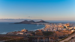 Cityscape. Panoramic view of the city of Las Palmas de Gran Canaria at sunset with Las Canteras beach and La Isleta mountains in the background