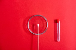 Petri dish with swab on red background stock photo