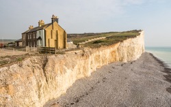 Coastal erosion, Sussex, UK. A diminishing row of terraced houses displaying the effects of weather on the chalk cliffs of the south of England.