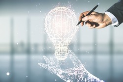 Male hand with pen draws abstract virtual light bulb illustration on blurred office background, future technology concept. Multiexposure