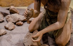 man set on fire with fire stone for cooking in stone age