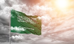 Saudi Arabia national flag cloth fabric on cloud background.