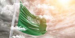 Saudi Arabia national flag cloth fabric waving on beautiful grey sky.