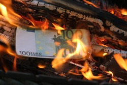 a 100 euro banknote is burning in a flame of fire. Close-up, horizontal photo. Concept - crisis, default, economic decline.
