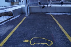 Electric car charging station on a public parking place. It is marked with electric car pictogram with electric plug instead of an exhaust.