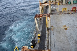 Stainless steel sharp barbed wire or razor wire attached to the ship hull, superstructure and railings to protect the crew against piracy attack passing Gulf of Guinea in West Africa. Areal view. 