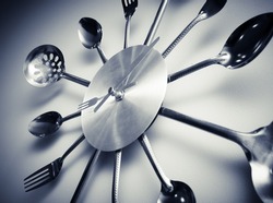 Kitchen abstract clock witch spoon and fork. Dramatic light used