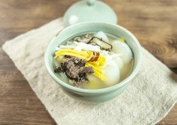 Close-up of Korean Food Tteokguk(rice-cake soup) with beef, egg garnish and shiitake mushroom, bowl, South Korea
