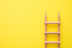 Creative idea, imagination, design and invention concept. Flat lay minimal style of staircase pencils on yellow pastel background with copy space. Outstanding idea is attractive.