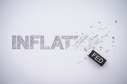 Word hand writing INFLATION is deleted by black FED eraser on white paper background copy space. The Federal Reserve ( FED ) increase % interest rates to fix inflation crisis. World economy concept.