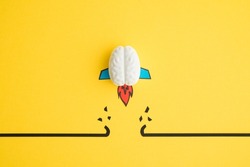 Brain rocket breaking through black wall obstacle on yellow background minimal style. Concept of breakthrough for new idea, innovative and successful goal in business financial.