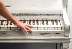 fingers of a young student's hands play excellent music from the keys of the old piano