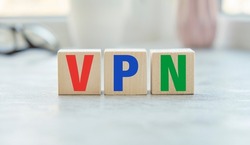 a wooden blocks with the letters VPN written on it on a white background. VPN - short for Virtual Private Network.