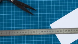 blue cutter mat with scissors, paper and ruler