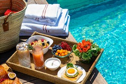 tray with assorted breakfast meal and drinks near swimming pool