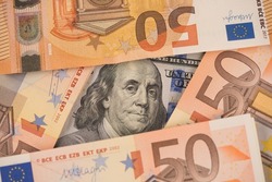 Closeup view of one hundred dollars banknote with euro money banknotes around as financial background. Cash money. Financial growth and business concept. Money background
