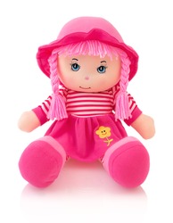 Pink plushie doll isolated on white background with shadow reflection. Cute pinky rag baby doll sitting on white underlay. Nice contemporary rag baby with pink hair. Modern joyfully rag baby with cap.