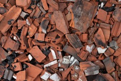 Broken terracotta tiles from burnt roof, smashed roof tiles, clay red tiles, roof destrucion