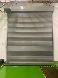 Automatic Factory Shutter Roller Door Indoor, Steel Rolling Gate Door for Security System of manufacturing, selective focus, out of focus, noise and grain effects.