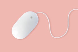 Simple white computer mouse with cord isolated on pastel pink background, minimal style