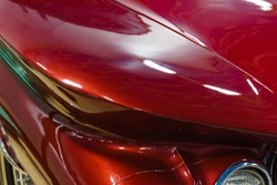 background - fragment of the surface of  red vintage car hood with smooth curved shapes