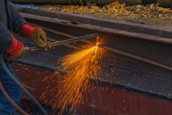 worker cuts scrap metal by thermal lance closeup