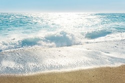 sea surf on a sandy beach on a windy sunny day
