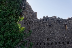 destroyed ancient fortress wall, entwined with ivy