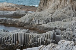 coastal landscape with beautiful columnar basalt cliffs at low tide