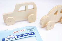 Car insurance documents and car toys. Translations: Parenthetical, Important, Postage Due, Auto Insurance, Maturity and Renewal Information.