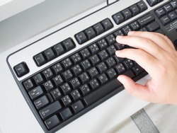 Hand typing on English-Thai computer keyboard
