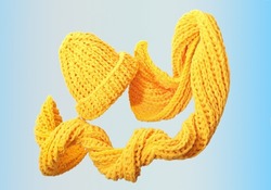 flying levitating scarf and hat. knitted winter woman yellow accessories. creative shot of warm apparel for autumn.