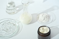 laboratory dishes and glassware on a lab table. fermentation, fermented beauty skin care. container with cream or solution or serum for anti age treatment, powder cosmetic ingredient