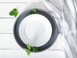 empty white plate on a table, dinner setting, mockup for food styling. tablecloth and cement round tray. Top view