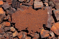 Rusty iron plate against a background of rusty pieces of metal. Design element. Old metal surface. Top view, copy space.
