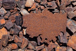 Rusty iron plate against background of rusty pieces of metal. Old metal surface, corrosion. Outdoor. Top view, copy space.
