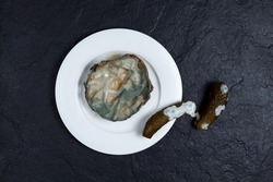 Concept - Expired food. Reduction organic food waste. Moldy portion of food on white plate and salted or pickled cucumbers with mold on dark background.