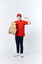 Professional delivery guy employee man in red cap T-shirt uniform workwear work as dealer courier hold cardboard box show muscles 