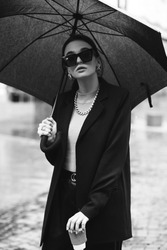 Young girl makes emotion.Dressed in a black shirt, black sweater, black hat, glasses and bright lips, fashion clothes.Wear vintage sunglasses, outfit and hat, leisure style, bright colors.Sensual woma