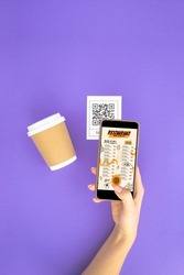 Top view Hand's customer scan QR code for online menu service at table in restaurant. New contactless technology lifestyle protection coronavirus pandemic in restaurant. Flat lay, purple background