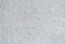 The texture of a rough, uneven concrete white wall
