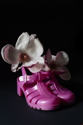closeup of bright pink jellies shoes with magnolia flower blossom