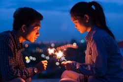 Couple holding bengal light at night,orange light,romantic,light bokeh