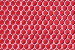 White laundry and sport mesh on red background. The fabric texture with hexagon shape stitching. Patterned background