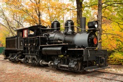 Colorful autumn leaves and old classic geared steam locomotive once used for hauling logs harvested in the White Mountains of New Hampshire.