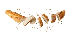 Cutting fresh baked loaf wheat baguette bread  with crumbs and seeds flying isolated on white background. 