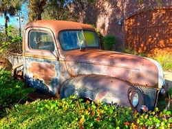 a rusted old vintage automobile car truck backyard junk garden monument display historic landscape background